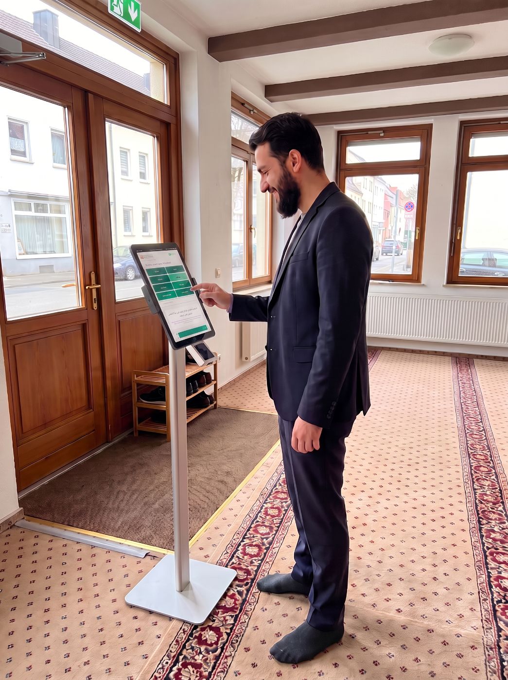 Ein Gemeindemitglied spendet an der HasanaTech-Spendensäule im Eingangsbereich der Moschee